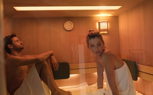 Paar entspannt in kleiner KLAFS Sauna mit warmem Innenholz in Hemlock