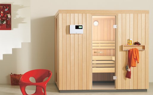 Kompakte Sauna HOME mit heller Holzverkleidung in einem modernen Raum mit Fitness-Accessoires.