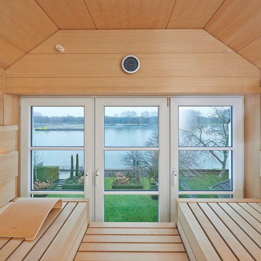 [Translate to Austria:] Sowohl vom Raum aus als auch beim Saunabaden ermöglicht die Klarglasfront ungestörten Blick durch die Fenster nach draußen.